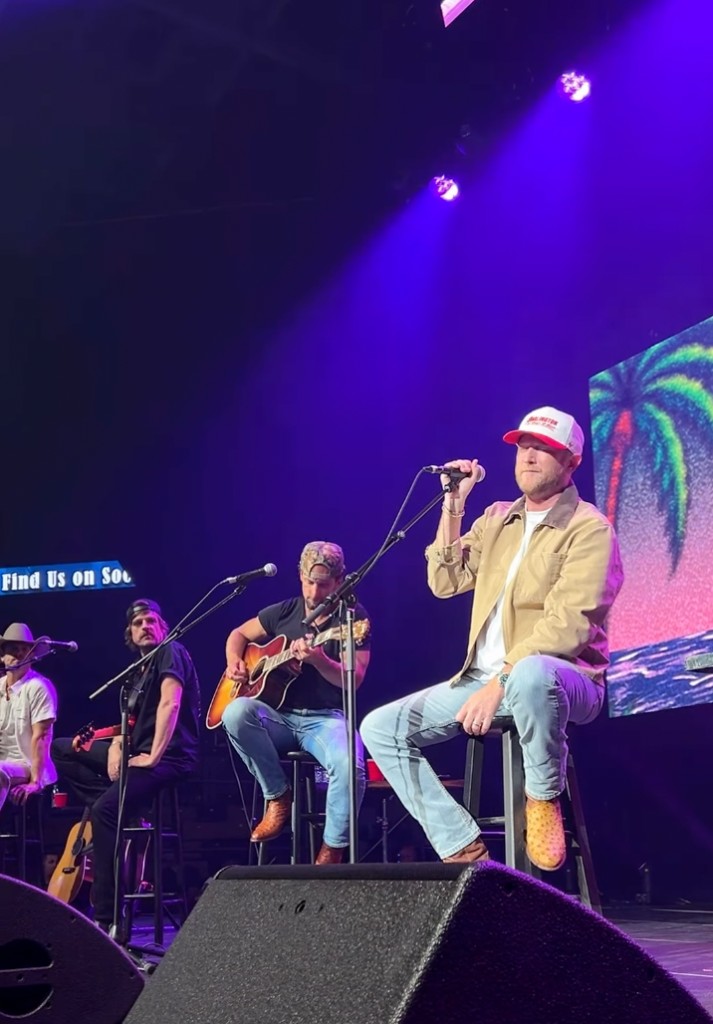 Artists seated together for an acoustic jam set