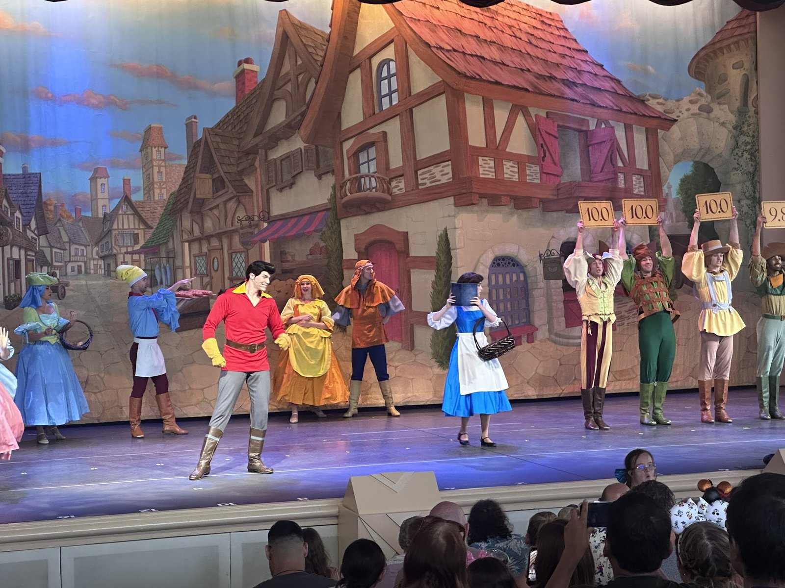 Gaston on stage with Belle and townspeople