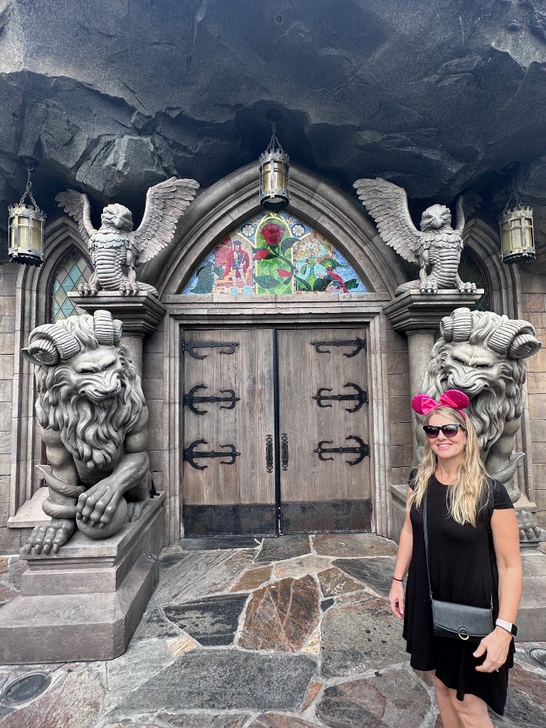Sarah at the lion-guarded doors of Be Our Guest