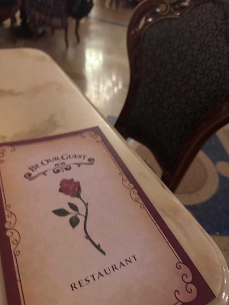 Be Our Guest menu with the rose on the cover