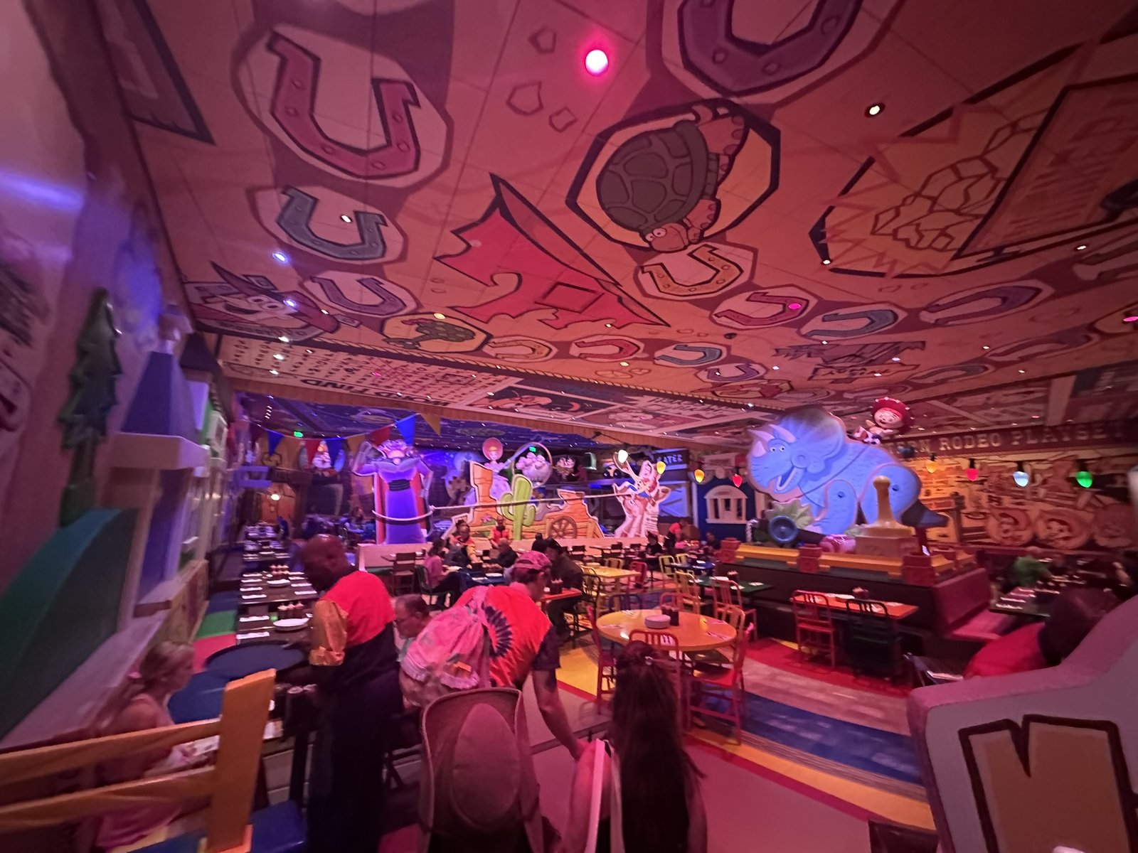 Crowded Toy Story–themed dining room with crayon ceiling drawings