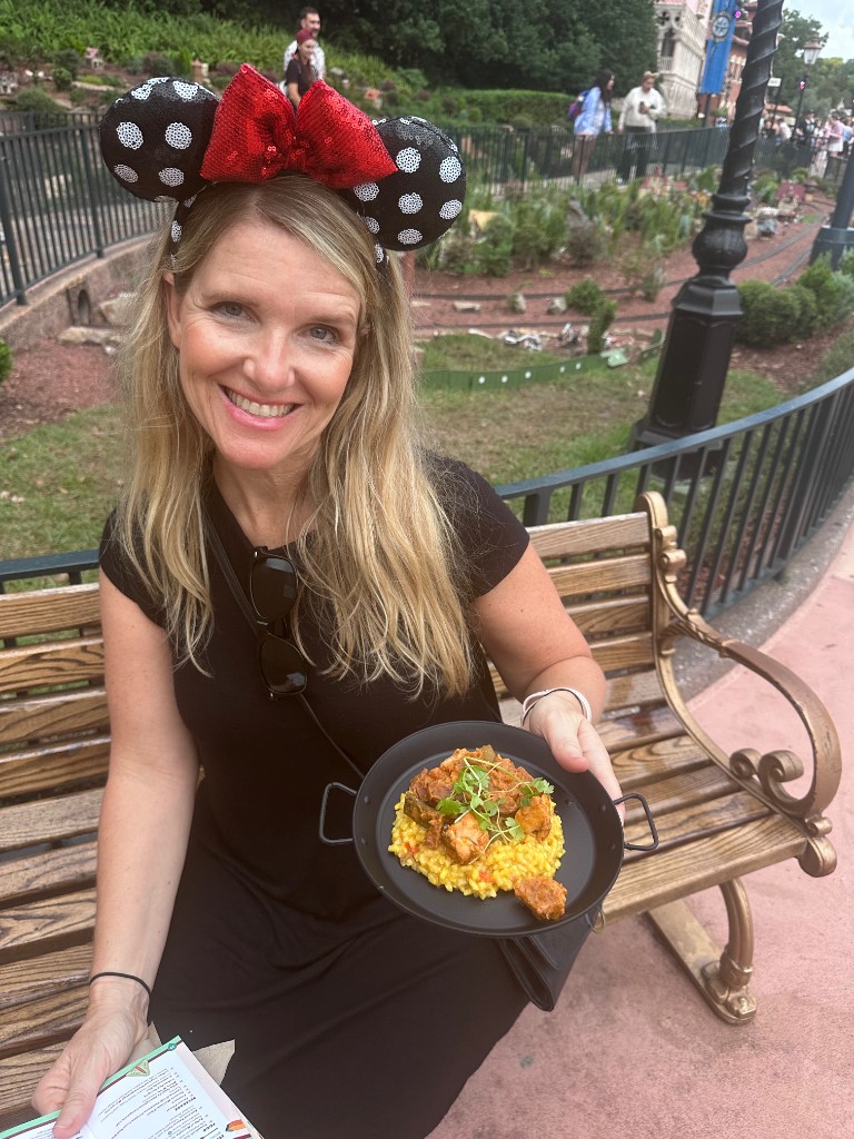Sarah with Spain paella on a World Showcase bench