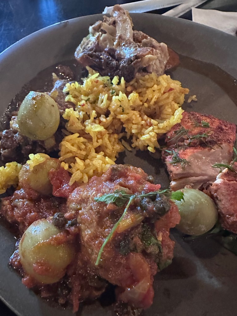 Plate with salmon, yellow rice, and African-inspired dishes