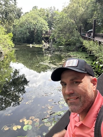Ryan on a wooden bridge over lily pads at Animal Kingdom