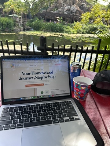 Laptop and Red Bull at a shaded table overlooking water near the Tree of Life