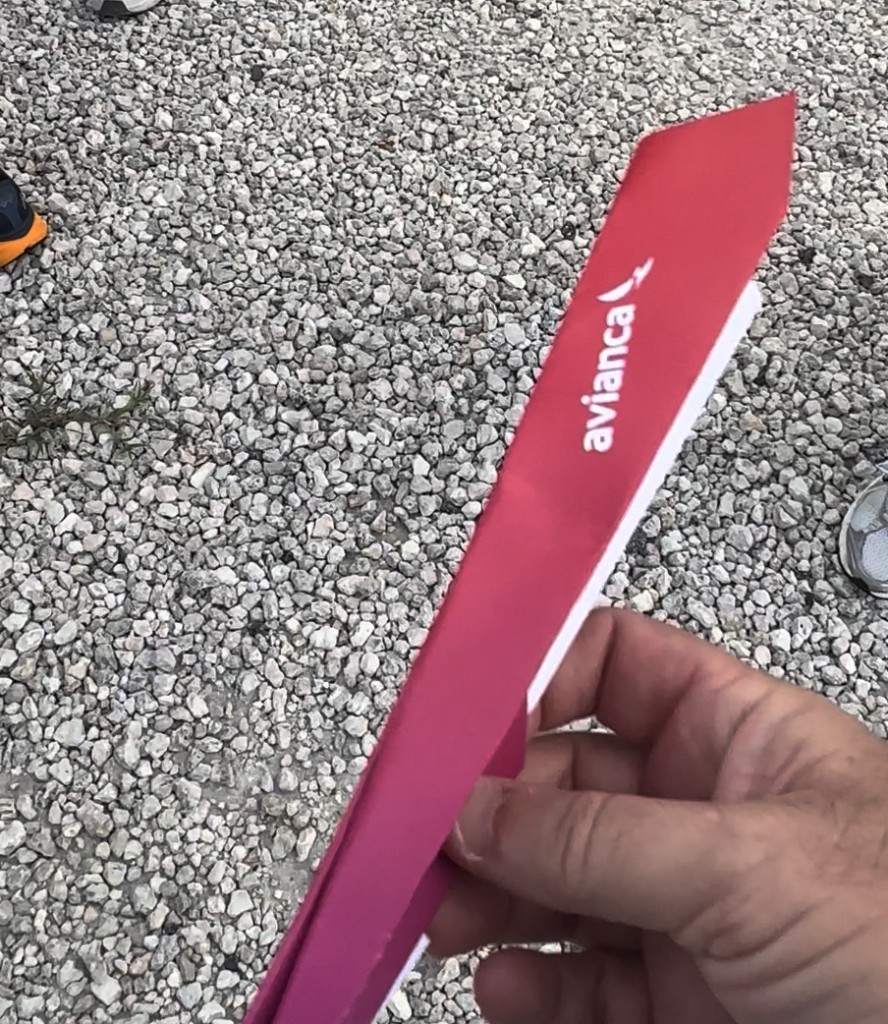 Red Avianca-branded paper airplane in hand