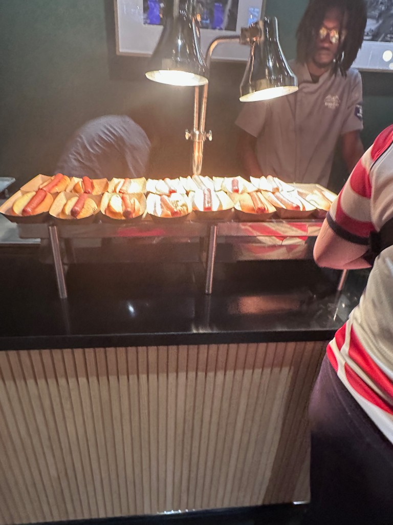 Hot dogs under heat lamps at the suite food station