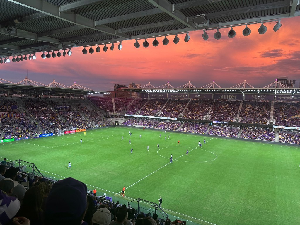 Live match under a red sunset with Avianca perimeter boards