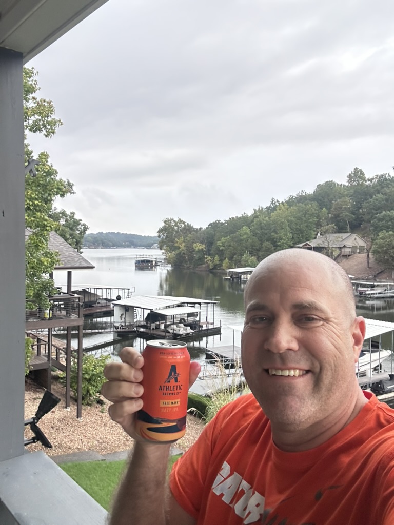 Ryan with an Athletic Brewing Free Wave on the lake-house deck