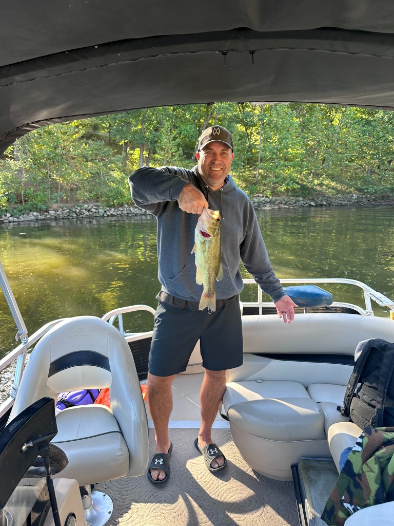 Ryan holding a bass on the boat