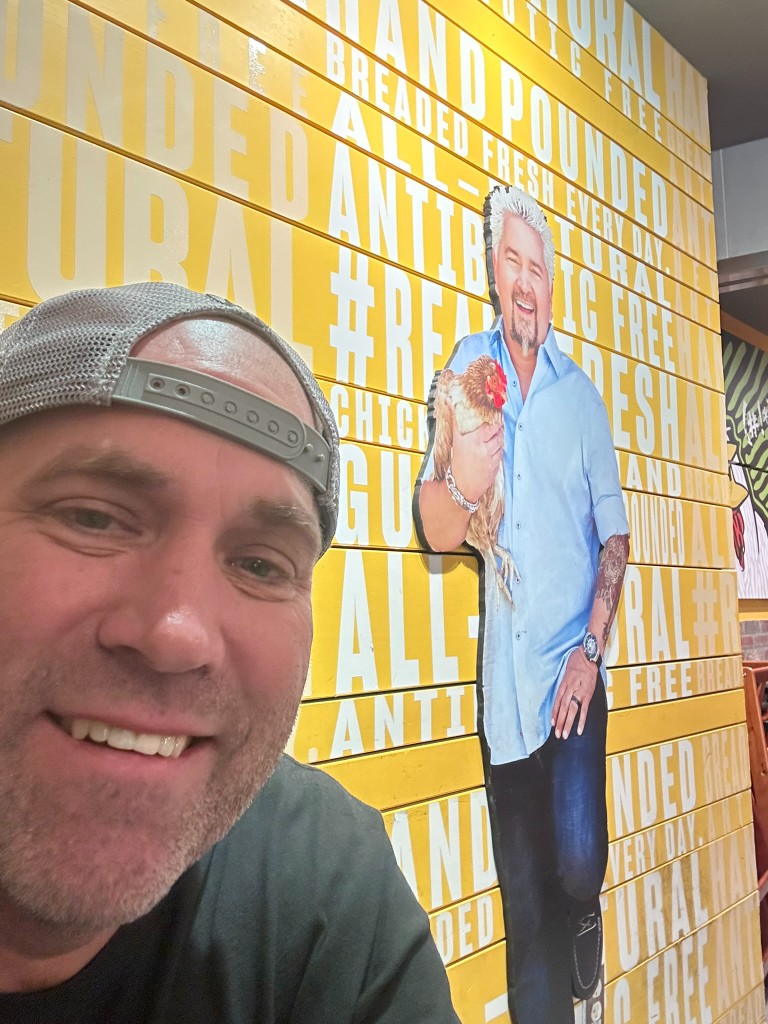 Ryan inside Chicken Guy! with the Guy Fieri cutout