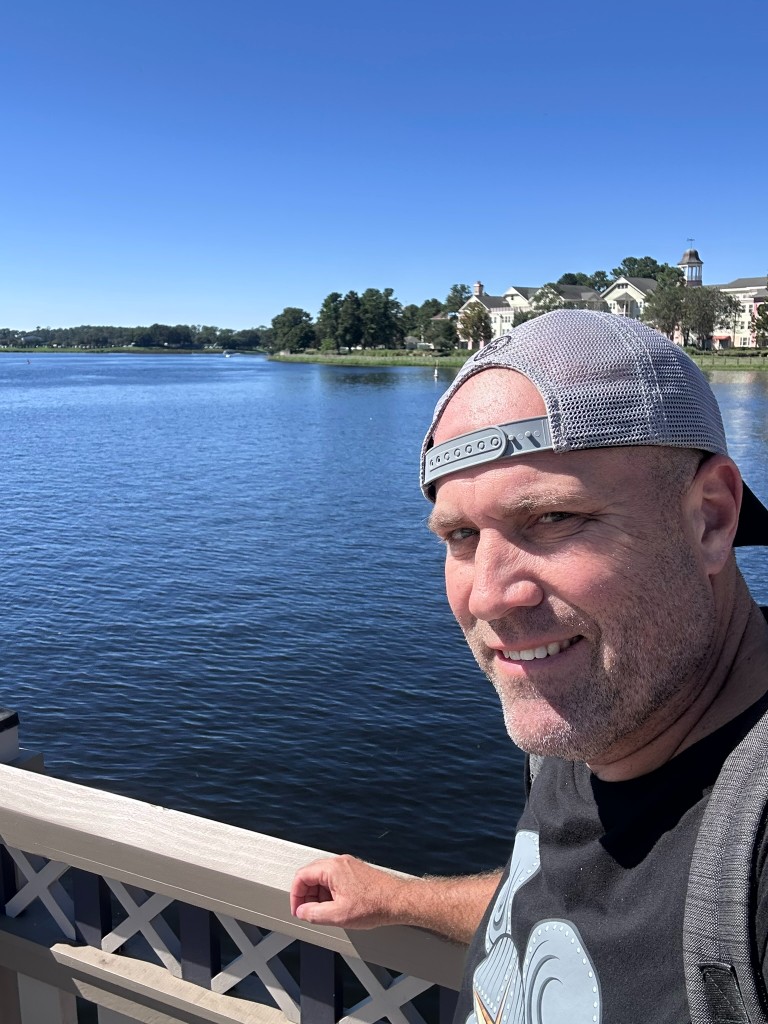 Ryan on a bridge overlooking the water at Disney Springs