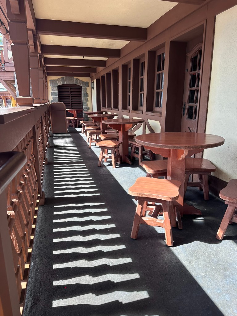 Empty covered balcony tables near Pinocchio Village Haus