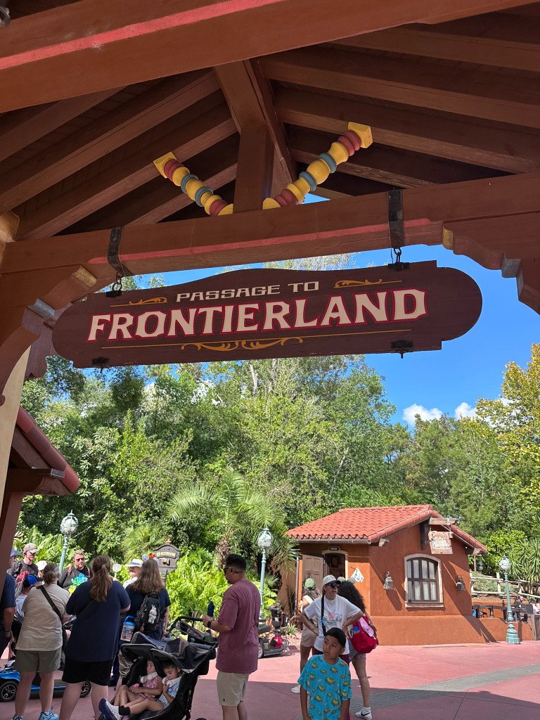 Passage to Frontierland wooden archway crowded with guests