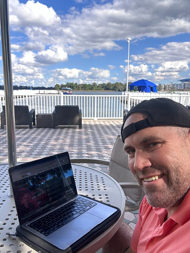 Ryan with laptop at a Contemporary lake patio table overlooking the water