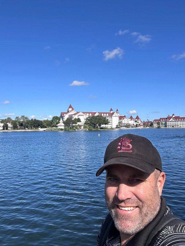 Ryan with Grand Floridian across the lagoon behind him