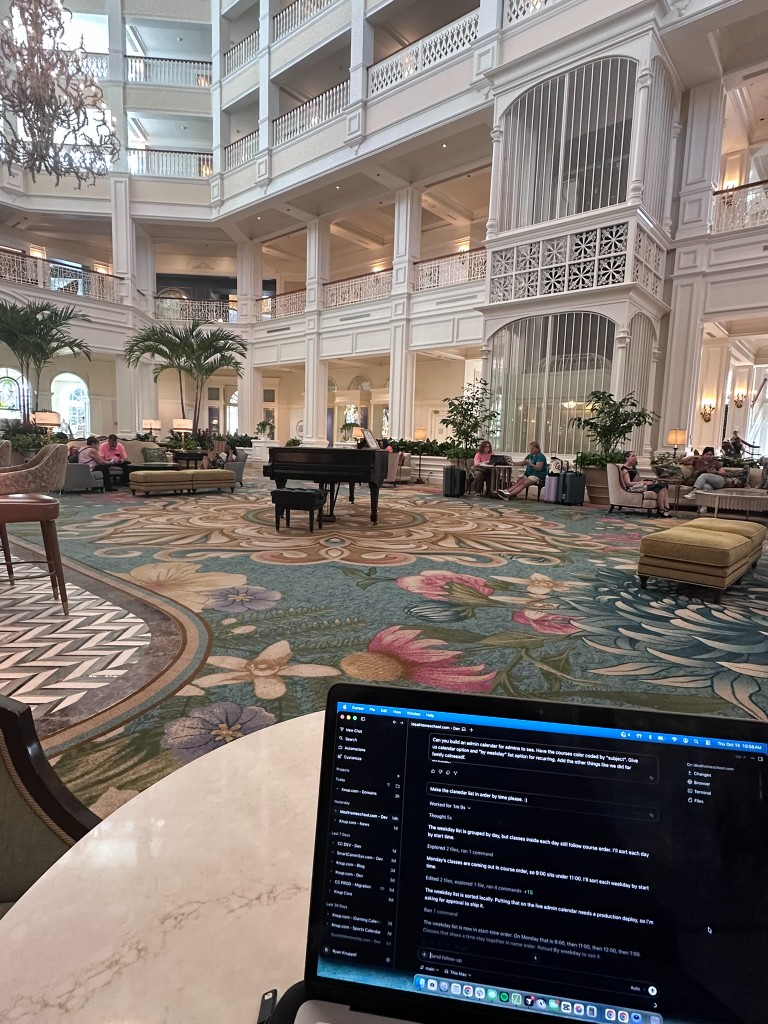 Laptop open in the Grand Floridian lobby with the atrium and piano behind