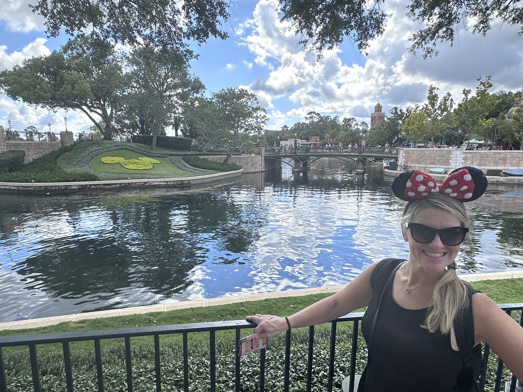 Sarah with a Food & Wine passport by World Showcase Lagoon
