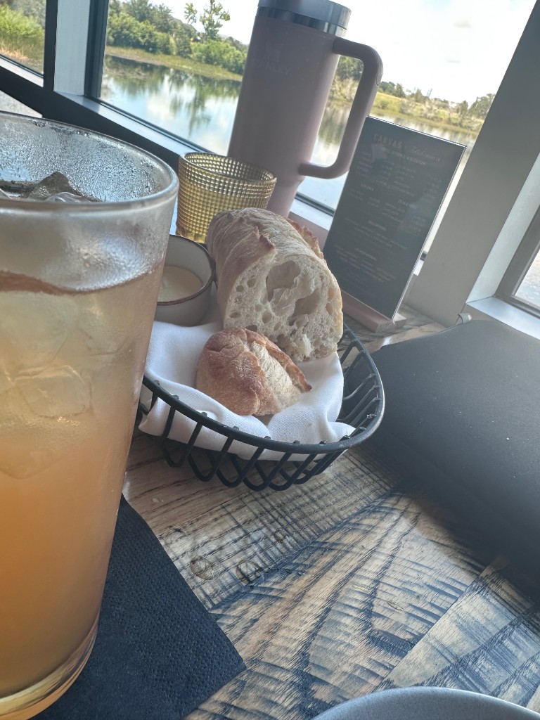 Bread, iced tea, and lake view from a window table at Canvas