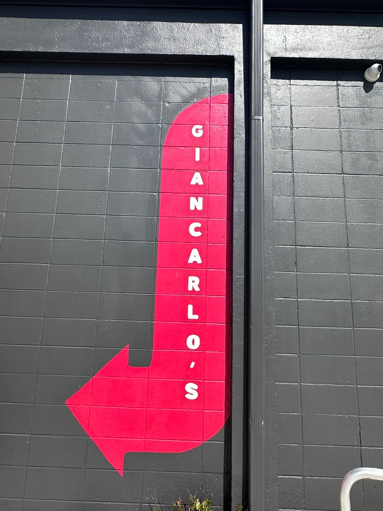 Pink Giancarlo's arrow painted on the black wall