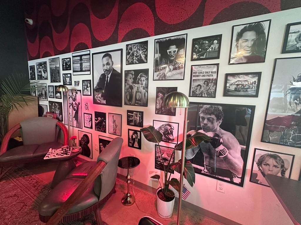 Interior lounge with gallery wall, chess table, and neon glow