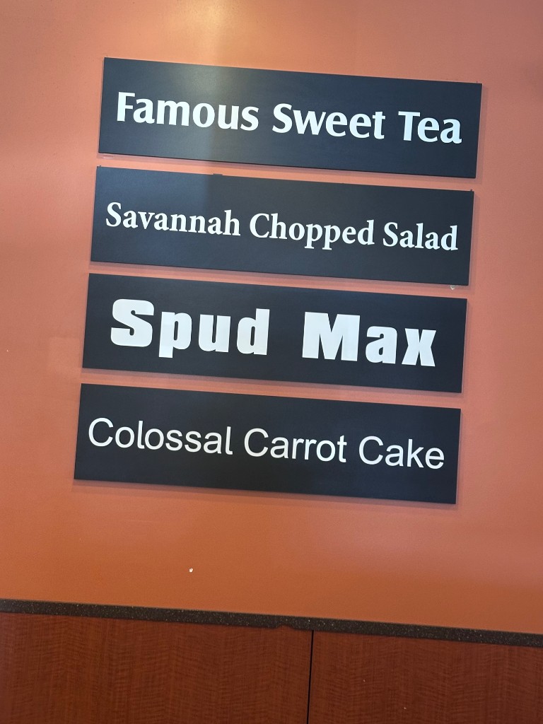Famous Sweet Tea, Savannah Chopped Salad, and Spud Max signs inside McAlister's