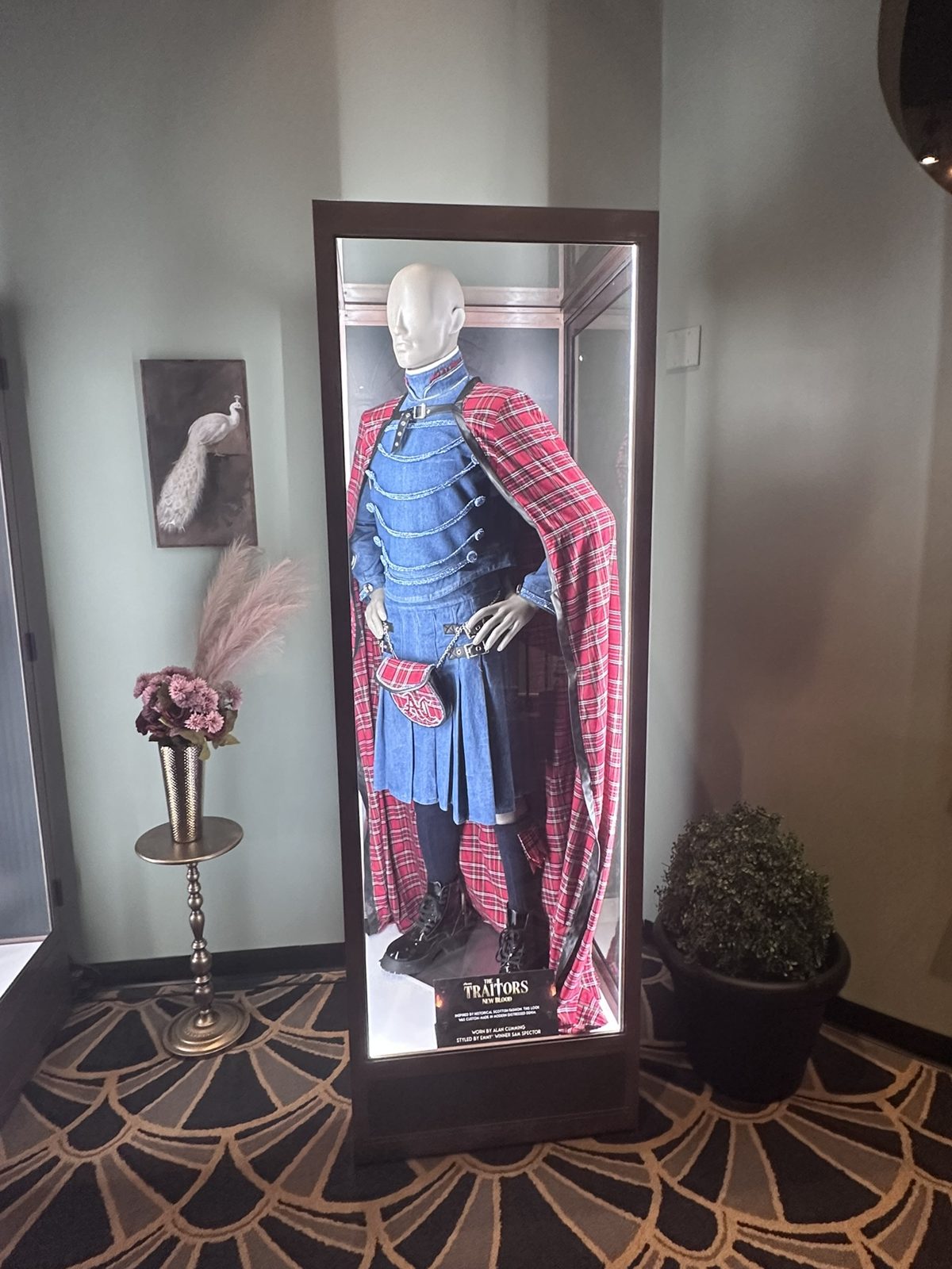 Denim and red tartan outfit worn by host Alan Cumming