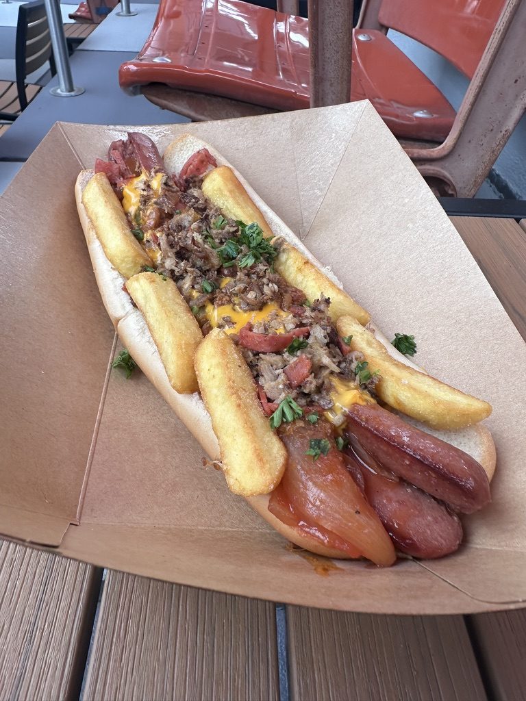 The Fat One footlong hot dog with pork, pepperoni, cheese sauce and fries in a paper boat